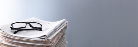 Pile of newspapers and optical glasses. Concept read newsの写真素材