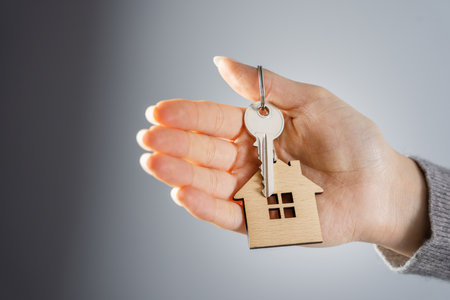 Woman holding house keys in her hand in the roomの写真素材
