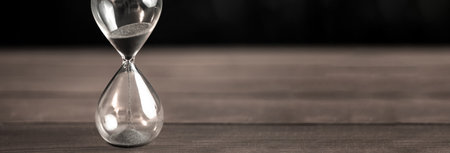 Hourglass on the wooden table backgroundの写真素材