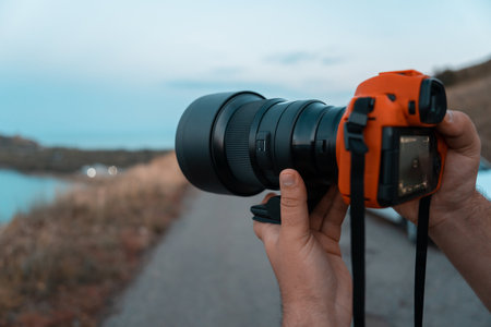 Photographer holding a camera outdoorsの写真素材