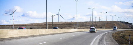 Road to the wind turbine under skyの写真素材