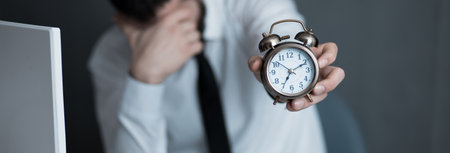 sad worker hand clock in office deskの写真素材