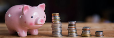 piggy bank with coins on tableの写真素材