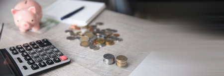 piggy bank with coins and calculator on deskの写真素材