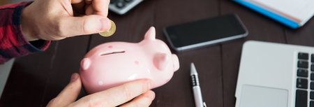 man hand piggy bank on working table