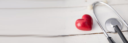 Heart and stethoscope on the wooden tableの写真素材