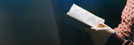 man reading Bible on dark backgroundの写真素材
