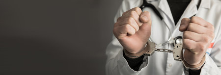 angry man doctor hand handcuffsの写真素材