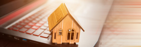 wooden house model on keyboard on deskの写真素材