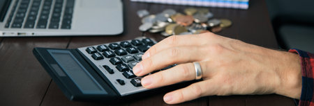 man hand coins with notepad and calculator on desk