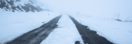 winter fog road in the mountainの写真素材
