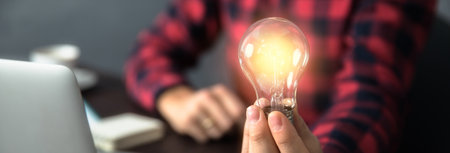 man hand light bulb on working deskの写真素材