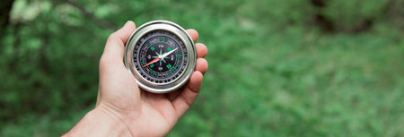 man hand compass in green forest backgroundの写真素材