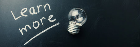 learn more text with bulb on boardの写真素材