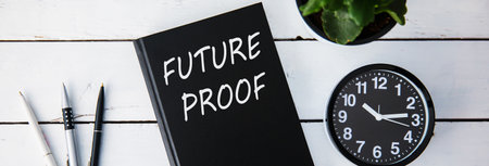 future proof text on book with clock on deskの写真素材