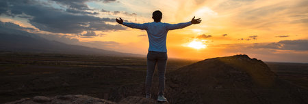 happy man in rock with color sunsetの写真素材