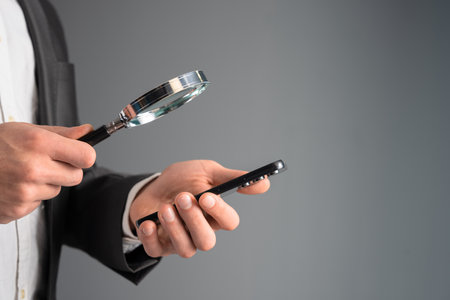 A man looks at a phone in a room with a magnifying glass