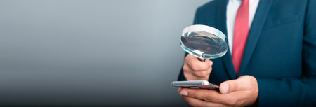 man hand holding smart phone with magnifierの写真素材