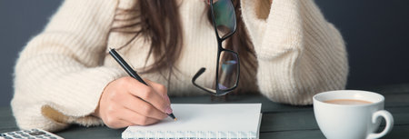 woman hand glasses with notepad on deskの写真素材