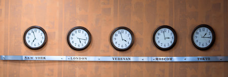 five clocks with different times on Teak backgroundの写真素材