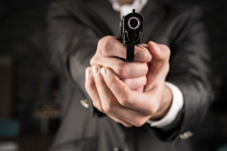 A man in a suit pointed a gun in the roomの写真素材