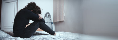 sad woman in bed in room backgroundの写真素材