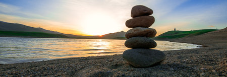Stones in balance at the sunset backgroundの写真素材