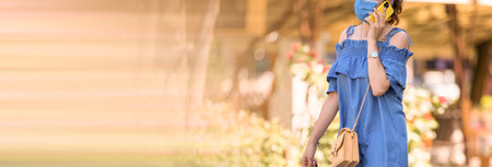 woman talking in phone face mask in streetの写真素材