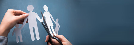 woman hand cut a paper family with scissorsの写真素材