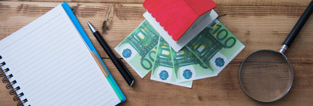 house model and money with notepad on tableの写真素材