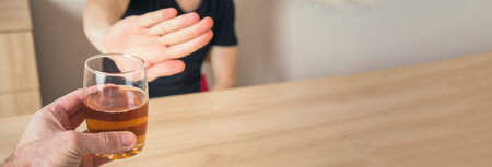 Man with glass of beer and man refusing to drinkの写真素材