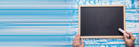 woman hand chalk and board on the blue tableの写真素材