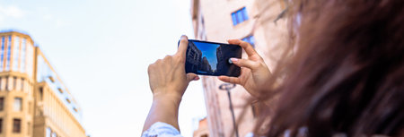 woman in phone take photos high-rise buildings