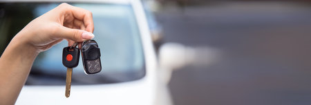 woman holding car key in the streetの写真素材