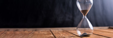 Modern hourglass on wooden backgroundの写真素材
