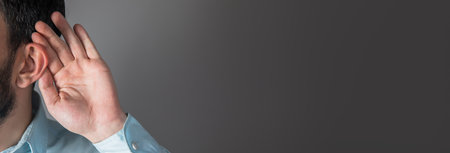 man hand in ears on gray backgroundの写真素材