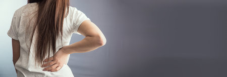 young woman hand in ache back