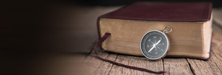 compass with Holy Bible on the wooden background