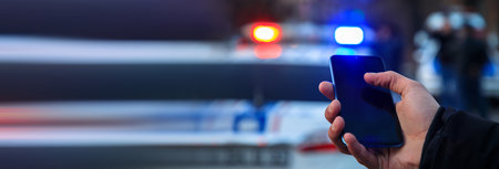 man holding phone with police in street