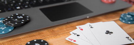 aces with poker chips on computer keyboard on table
