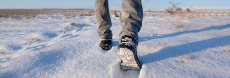 man walking in the snow in sunny dayの写真素材