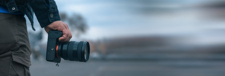 young man holding camera in street