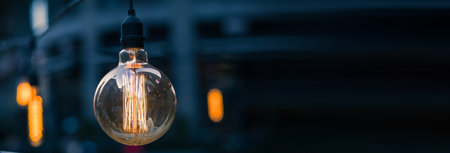 Vintage light bulb glowing in the darkの写真素材