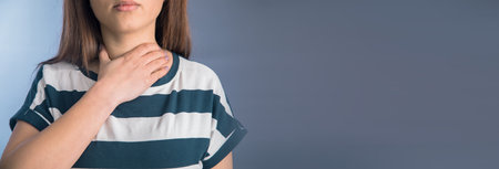 Young sad woman holding ache neckの写真素材