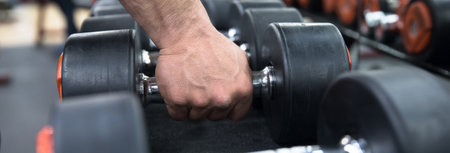 fitness man bodybuilder is workout with dumbbells in gymの写真素材