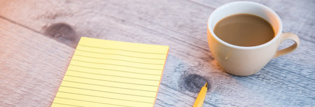 notepad with cup of coffee and pen on tabeの写真素材