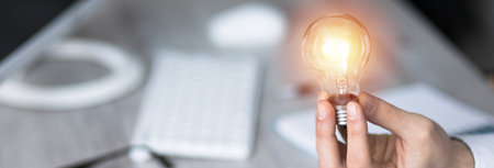 business man holding light bulb in working table