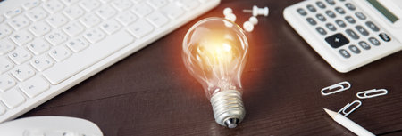light bulb with computer on working tableの写真素材