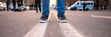 man standing in two white lines in street