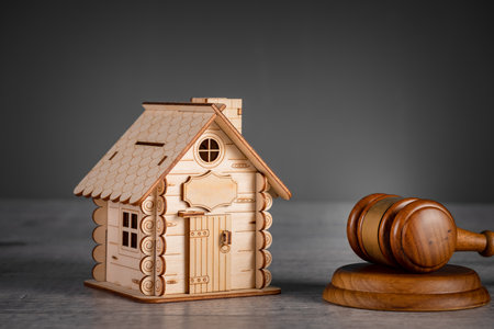 A decorative wooden house with a judge's gavel next to itの写真素材